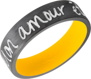 Zirconium 7mm flat band with slightly rounded edges and a laser-carved handwritten message with a yellow Cerakote sleeve